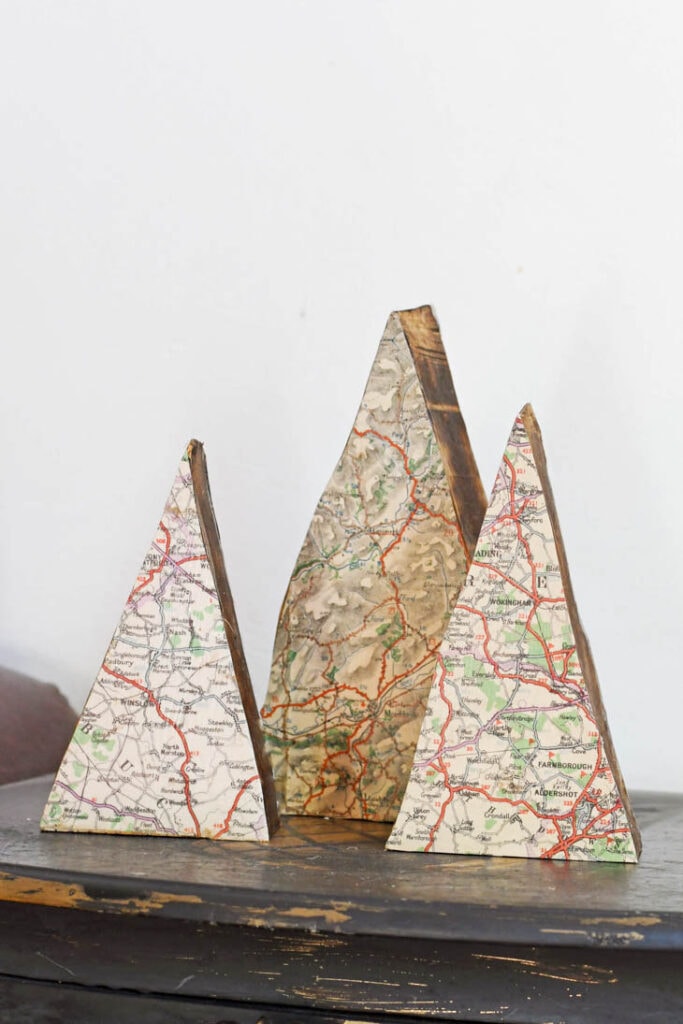Triangle shaped scrap wood as Christmas trees with maps decoupaged onto them