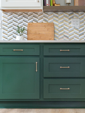 Green kitchen cabinnets with tile backsplash