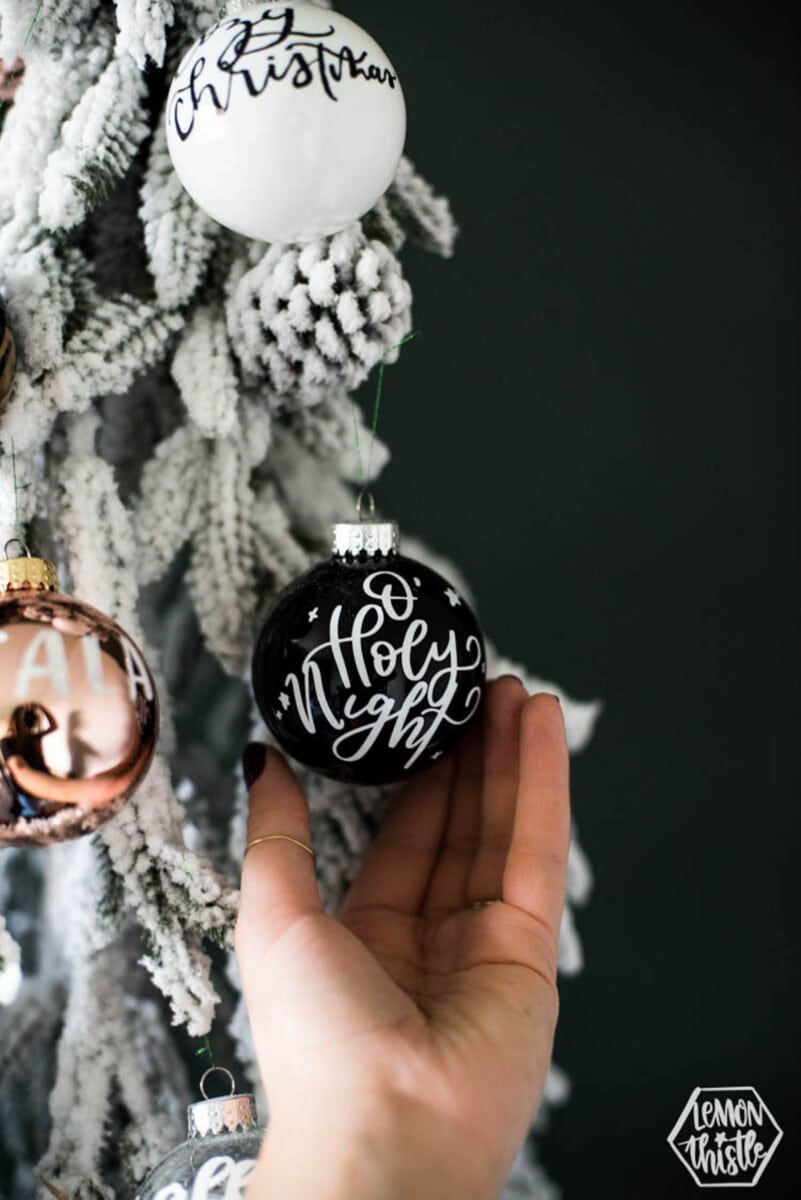 Black round ornament with white vinyl letting "Holy Night"