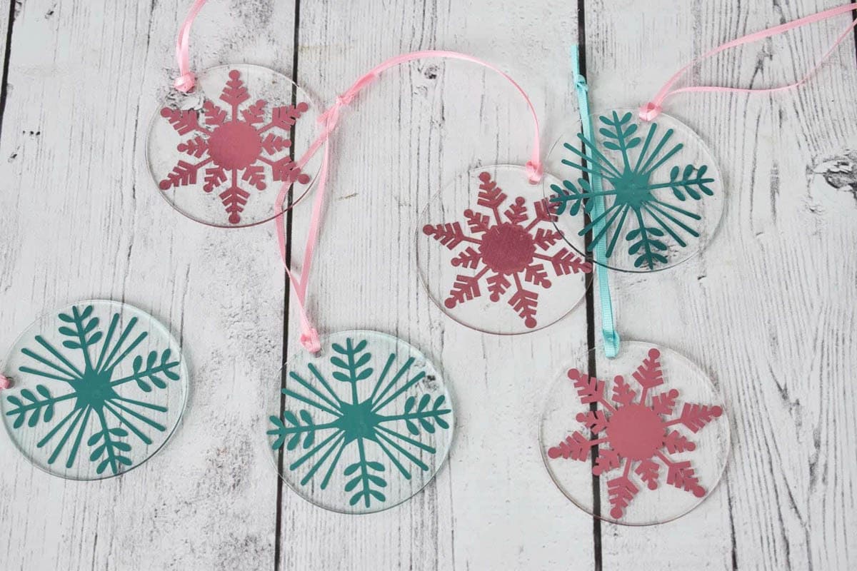 Assortment of acrylic ornaments with vinyl snowflakes made with a Cricut