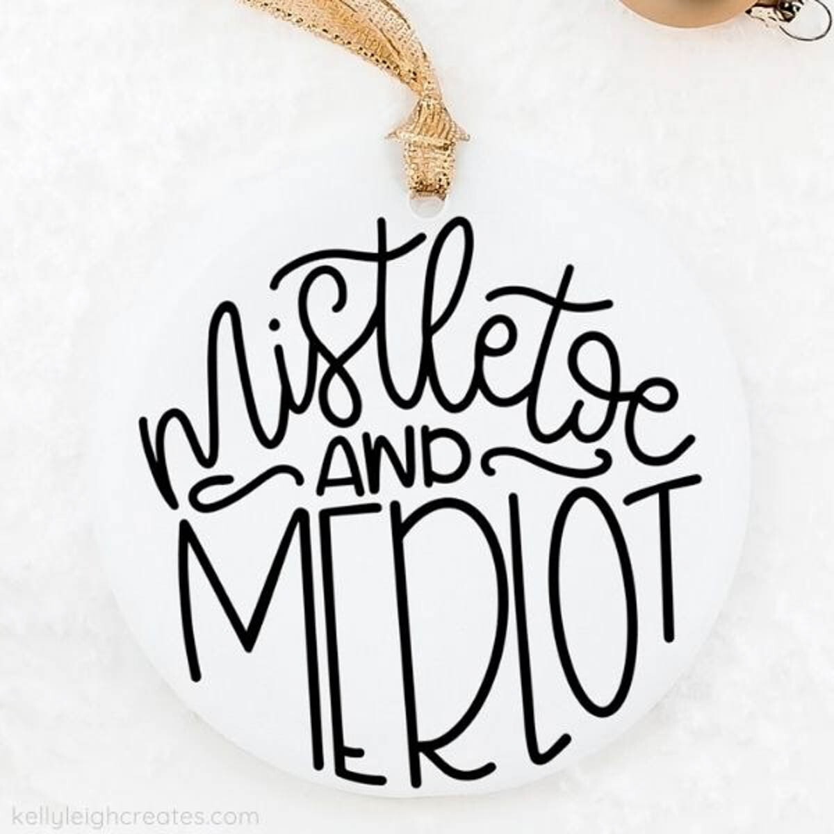 Mistletoe and Merlot added to a white round ornament using Cricut vinyl