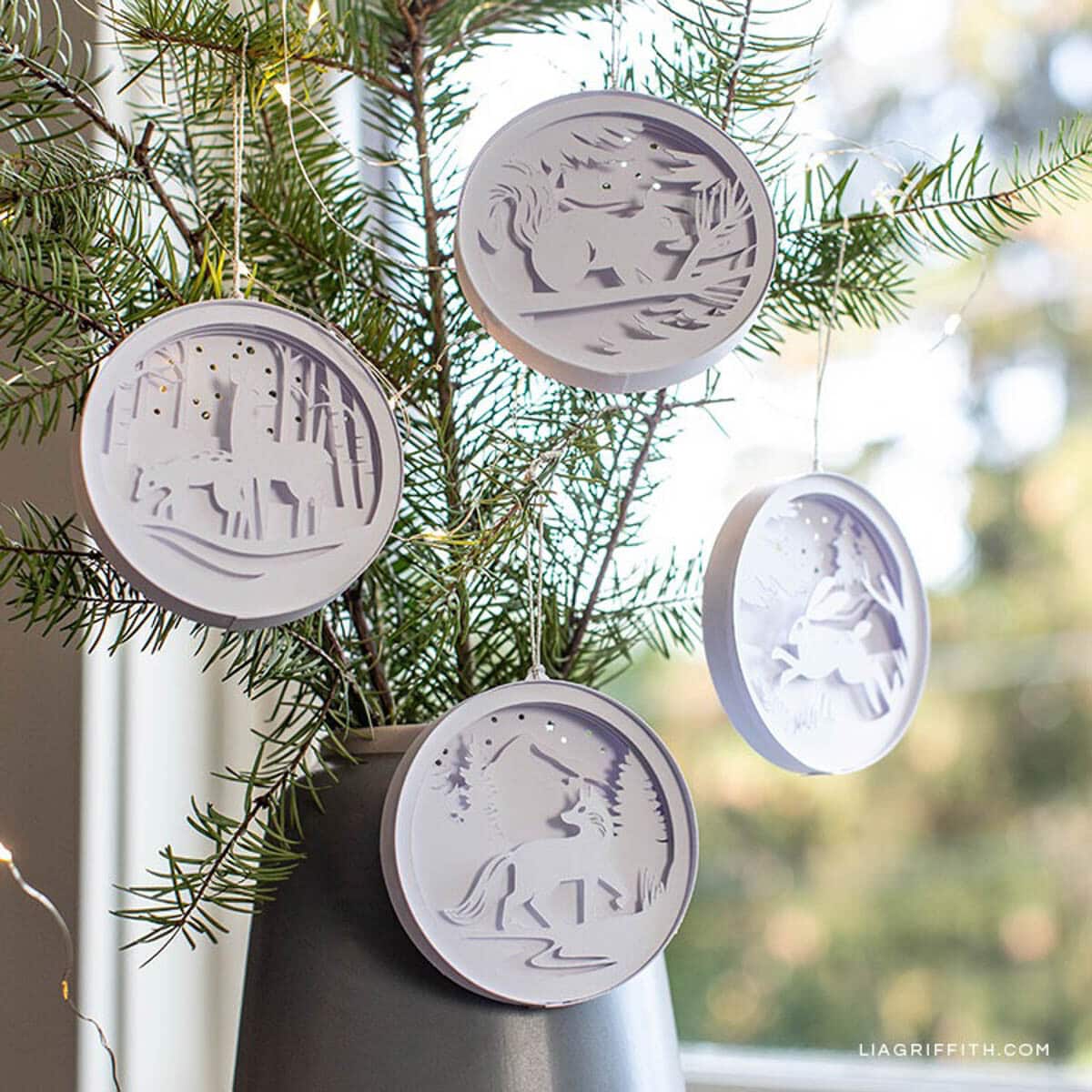 paper Christmas ornaments with intricate woodland designs