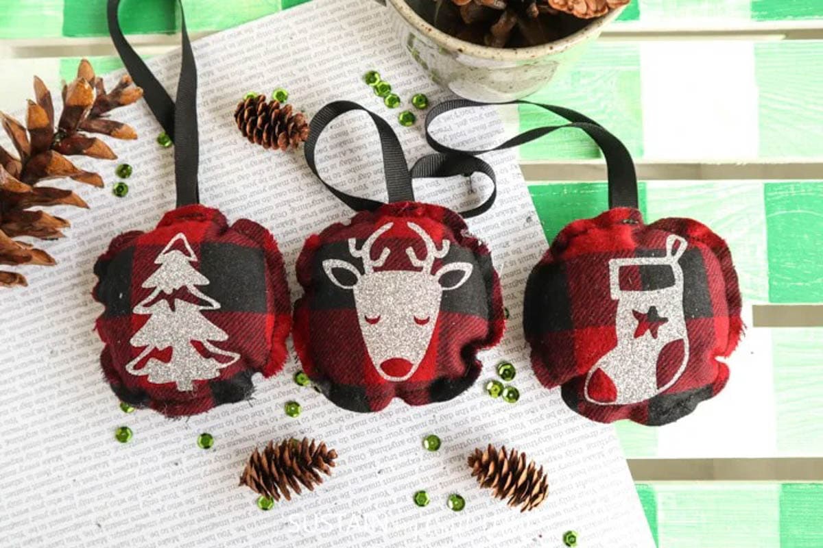 Three ornaments made with flannel fabric and Cricut vinyl
