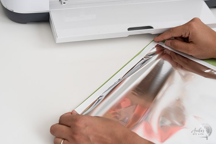 Woman applying tape to attach the Cricut Transfer foil