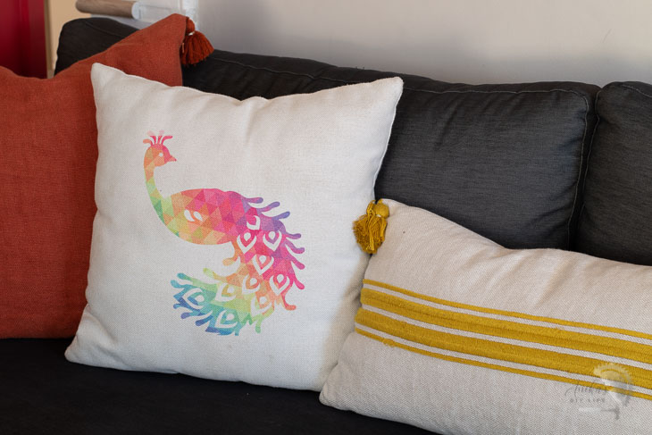 Colorful peacock pillow on couch