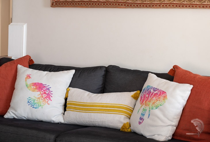 colorful pillows with peacock and elephant on couch