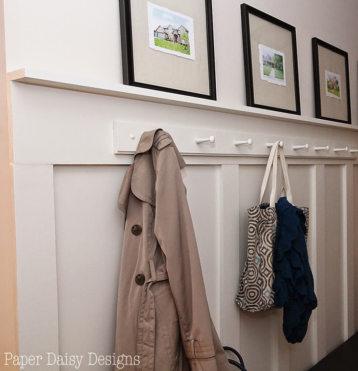Entryway with board and batten with hooks and ledge with pictures
