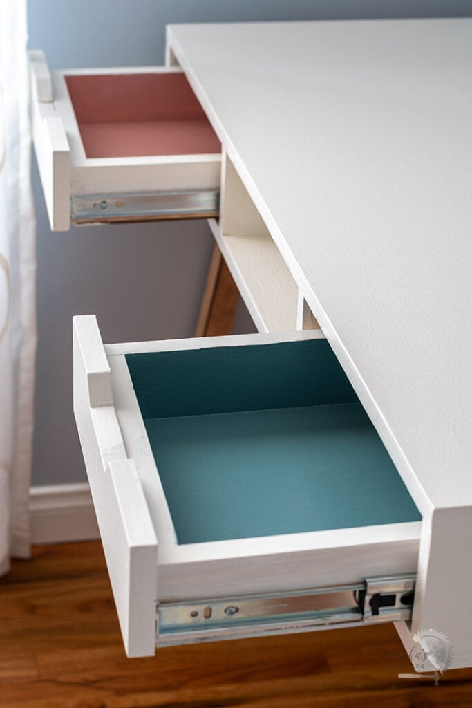 desk with drawers open with pink and turquoise interiors