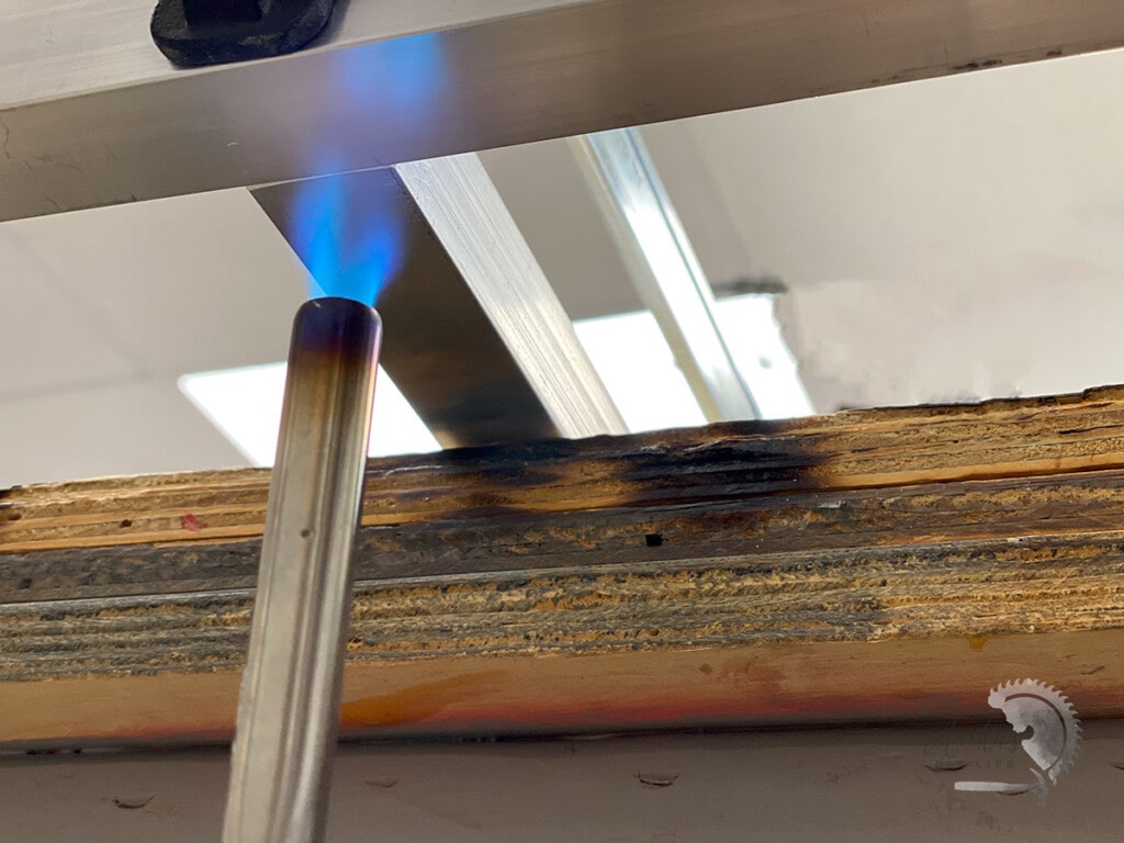 close up of blowtorch heating the aluminum joint