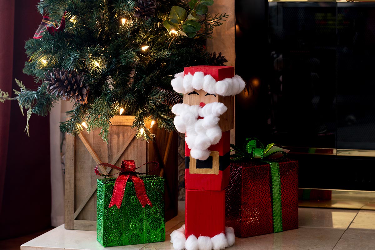 wood block Santa by the tree with presents