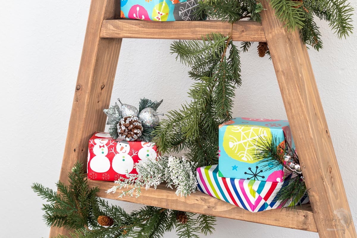 close up of christmas tree shelf with gifts on it.