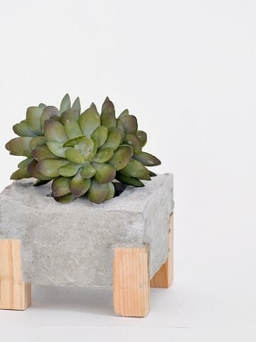 How to make a DIY Concrete Planter with Wooden accents. This DIY concrete and wood planter is easy to make and creates a gorgeous concrete planter with an unexpected twist.