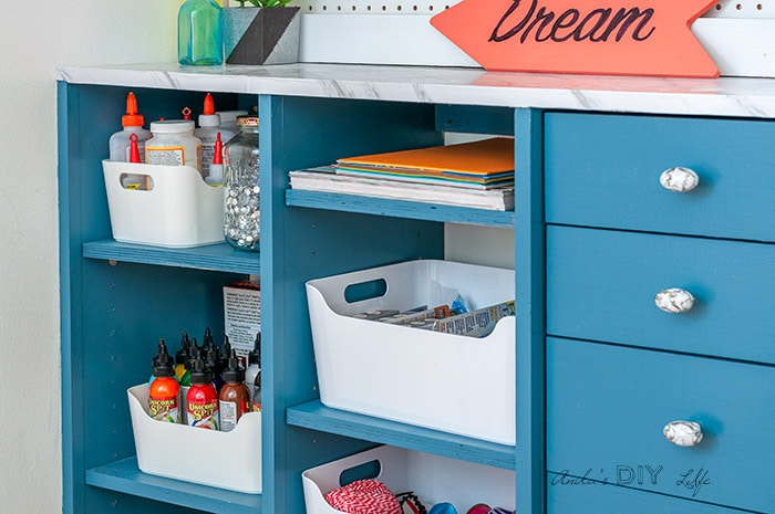 Close up of shelves and drawers of DIY craft closet organizer with drawers