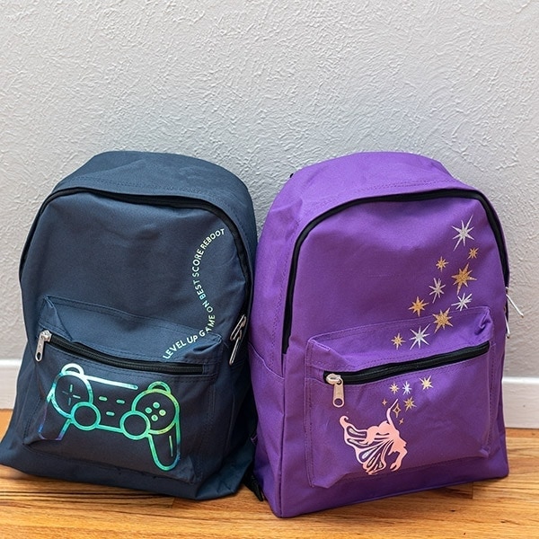 Learn how to make DIY custom backpacks using Iron-on vinyl and Cricut. This is a great way to make special designs and personalize any backpack! We made these to donate to the wonderful cause - Backpacks of Love.