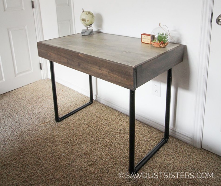 Small wooden desk with black metal pipe legs and hidden drawer