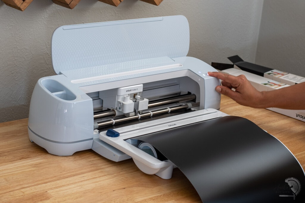 Woman running the Cricut Maker 3 with a black roll