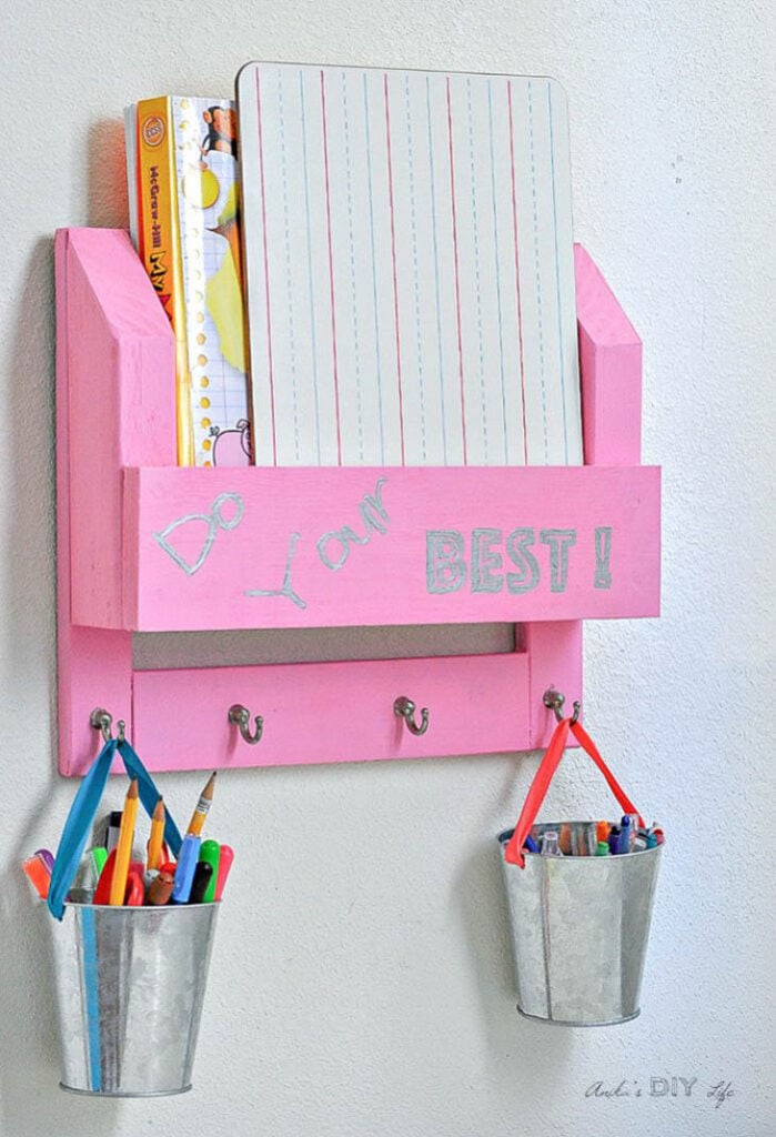 Pink DIY desk organizer with aluminum pails hanging from the hooks with pencils and crayons