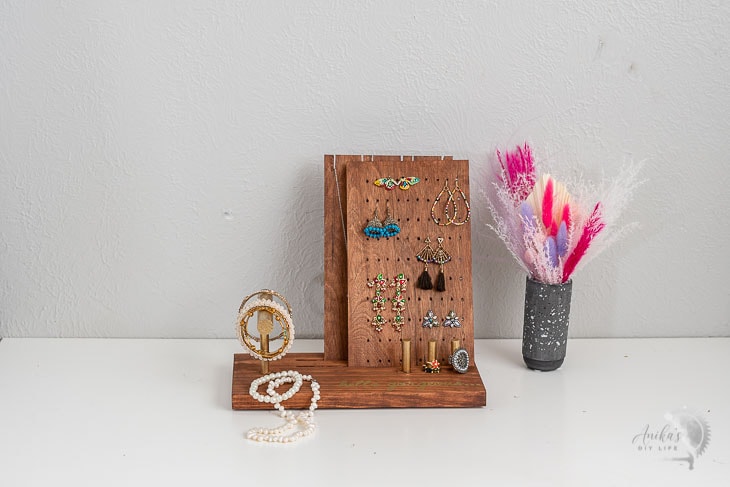 DIY jewelry holder on table with pink flowers