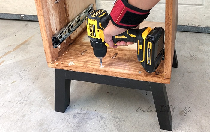 Attaching legs of the nightstand to the top frame using wood screws