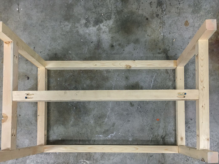 DIY outdoor coffee table with top frame and leg support attached.