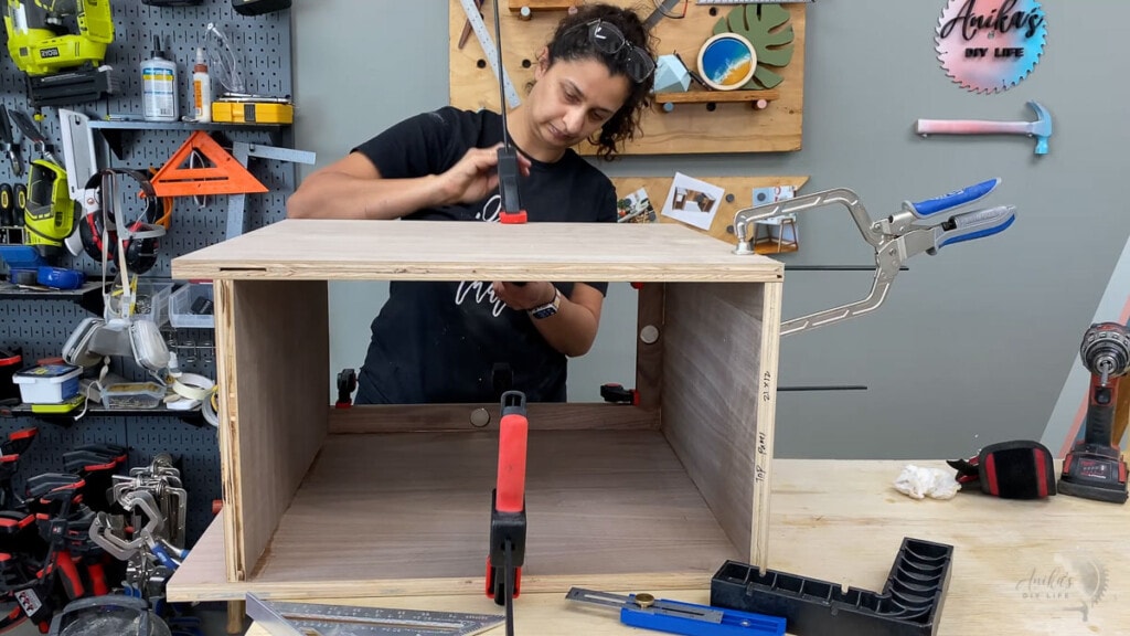 woman building the speaker compartments for the diy record player stand