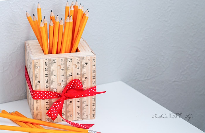 DIY pencil holder made from scrap wood and rulers on table with yellow pencils
