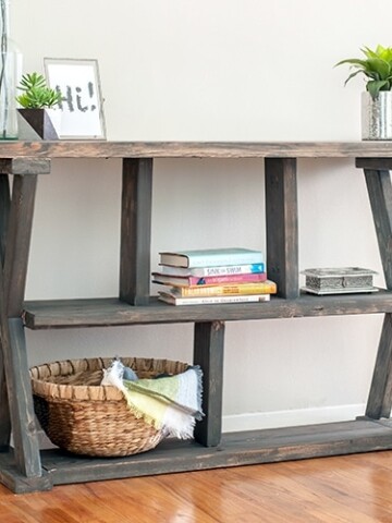 DIY Rustic X-leg Console table that is easy and quick to build with the Free plans. This DIY Entryway table with shelves is made using structural lumber so it's great for your budget too!