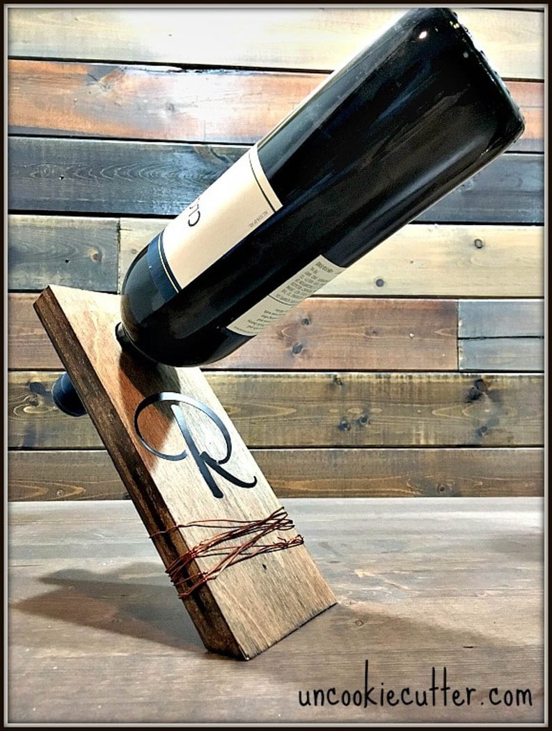 wine bottle placed inside a holder made from scrap plywood