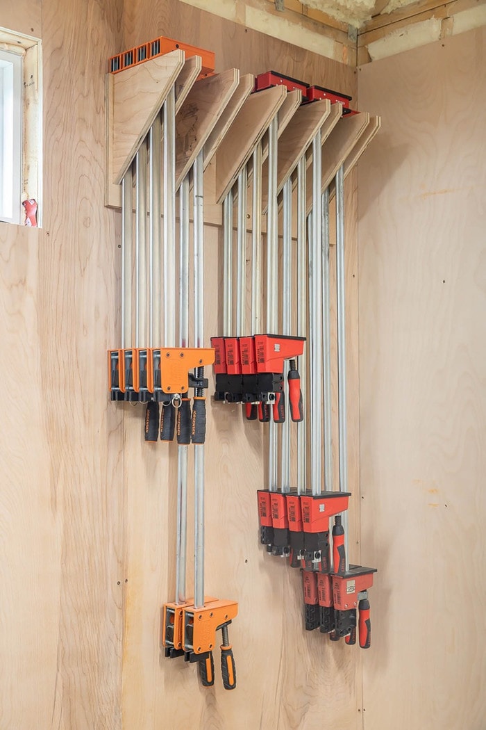 wood clamps hanging on the wall in an organizer