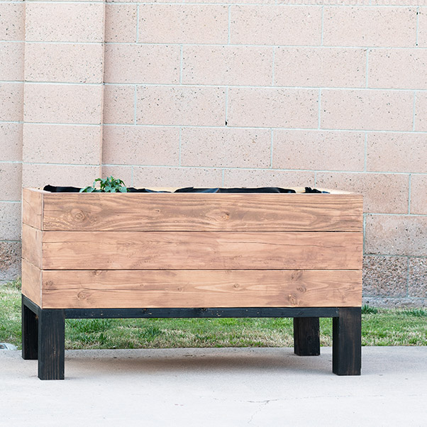 Learn exactly how to build a DIY self watering planter box. This sub-irrigation modern raised planter is perfect for any yard!