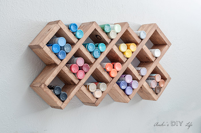 DIY spice rack hanging on the wall filled with craft paint bottles