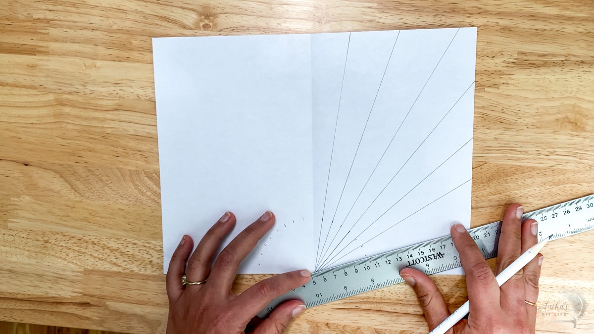 woman drawing a sunburst pattern on a piece of paper