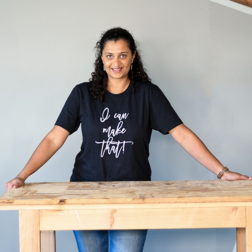 Woman wearing "I Can Build That" T-shirt in workshop