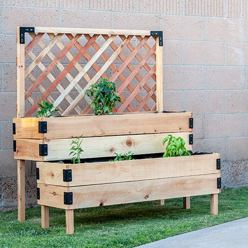 DIY Tiered raised vegetable bed with legs and trellis in backyard with vegetable plants