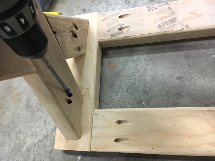Attaching the 2x4 legs to the top frame of the bench with pocket hole screws