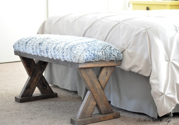 DIY upholstered X-leg bench made with 2x4 boards as an end of the bed bench.