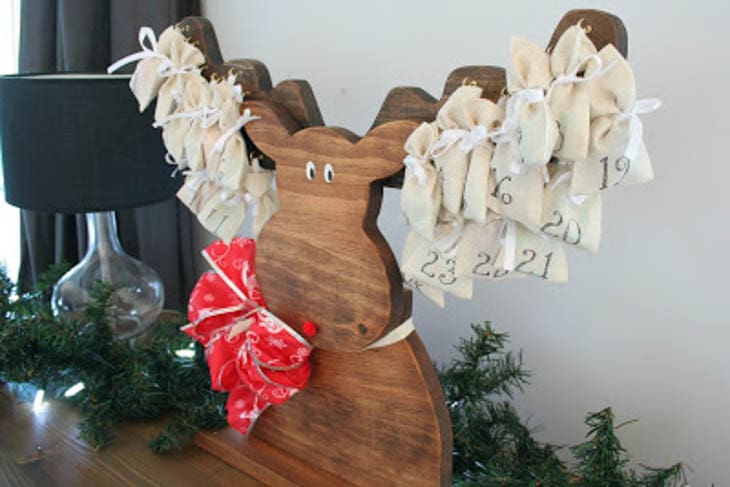 Wood moose advent calendar with day markers hanging on antlers