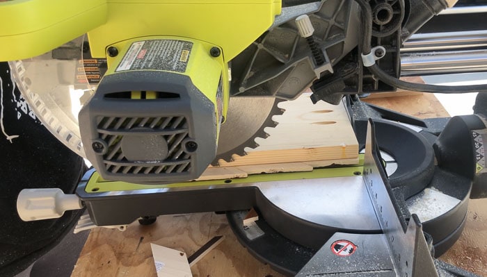cutting off extra overhangs on the panels with miter saw