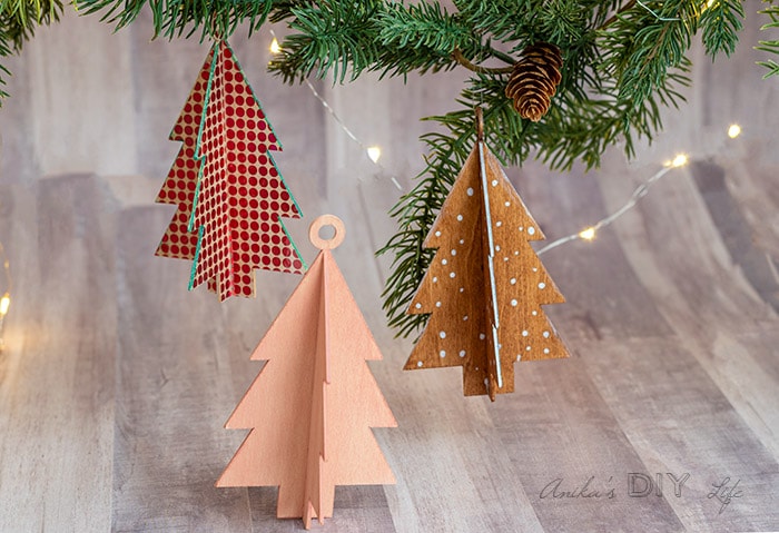 DIY Christmas tree shaped wooden ornaments hanging from branch