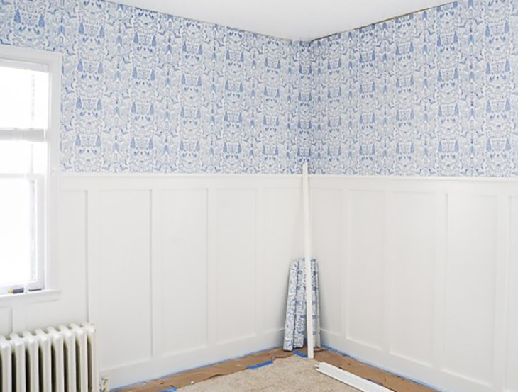 Room with half wall board and batten and wallpaper on top