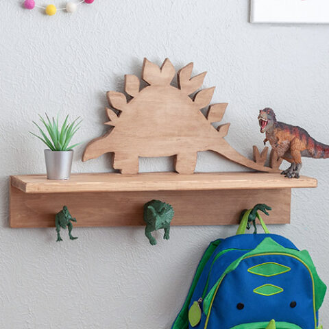 Dinosaur shelf with dinosaur hooks with small plant, T-rex and a bag