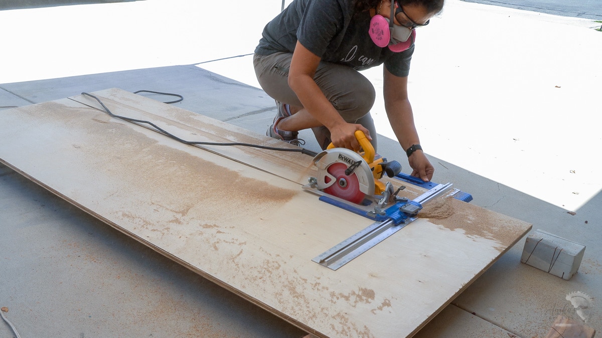 Woman cutting down a sheet of plywood with a circular saw