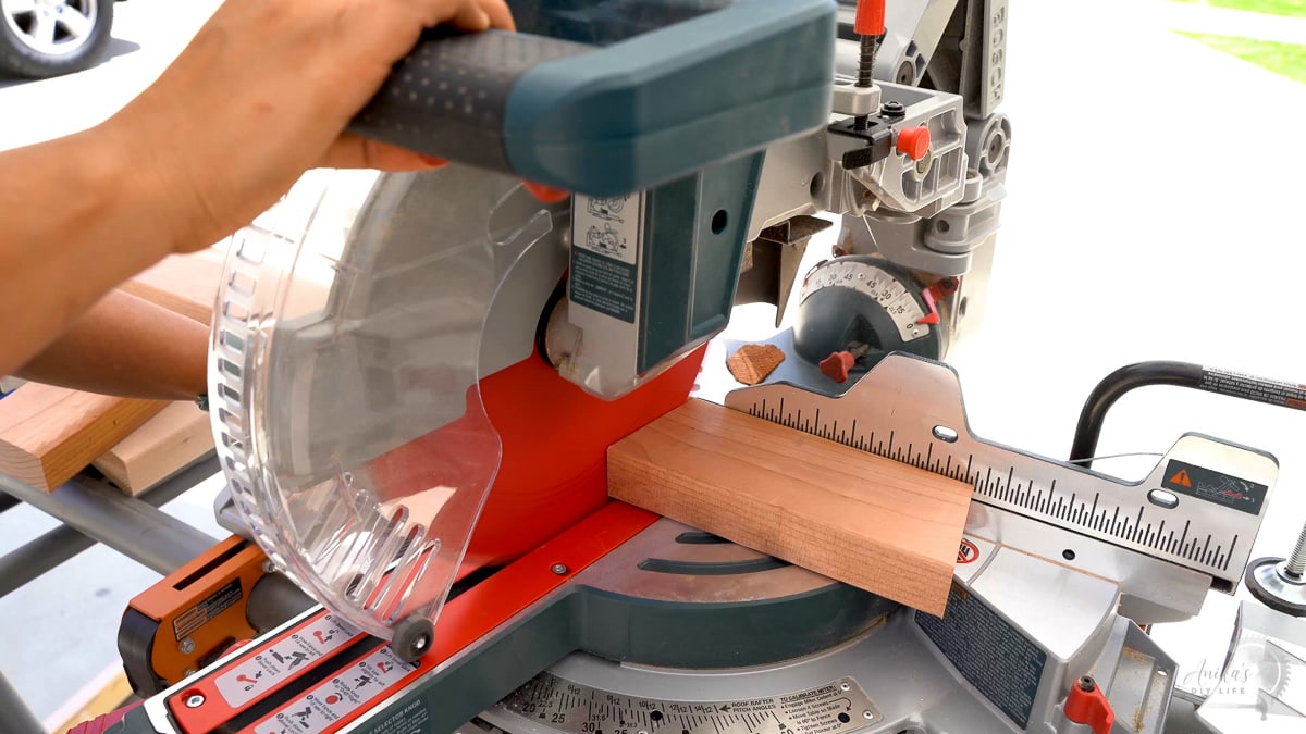 cutting an angle in redwood 2x4 on a miter saw