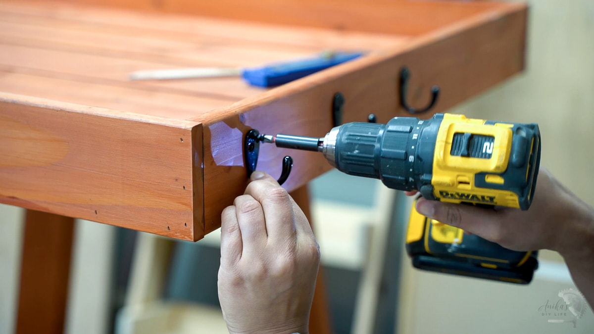 attaching hooks to the side of the potting bench with a drill