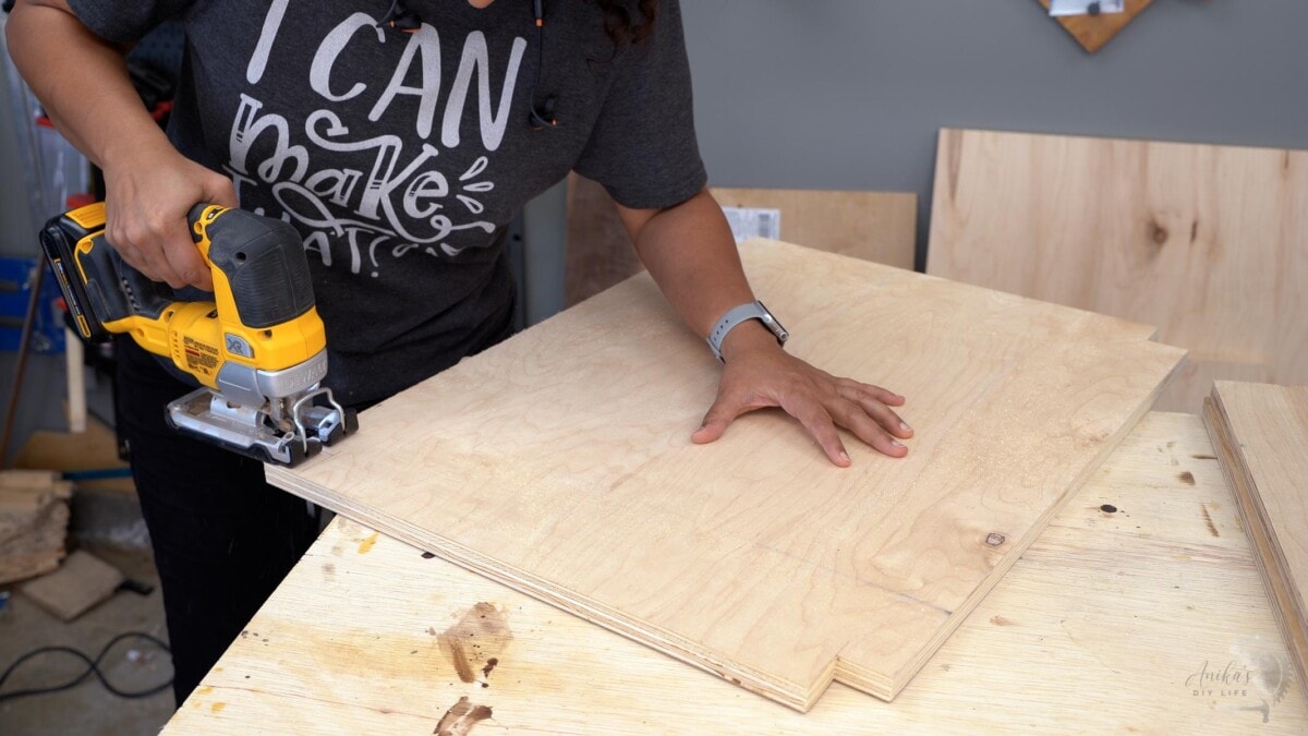 woman cutting edges of plywood using a jigsaw
