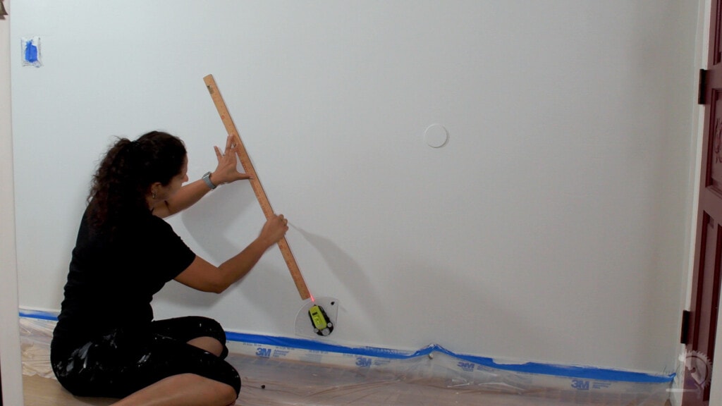 Woman drawing lines on a white wall