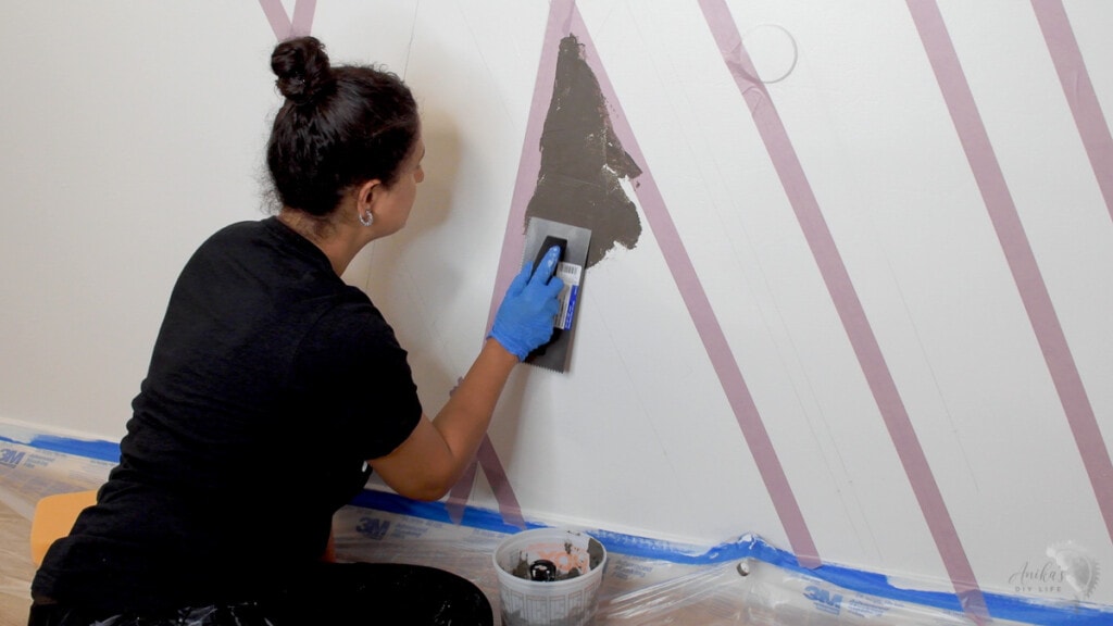 Woman applying cement to the wall