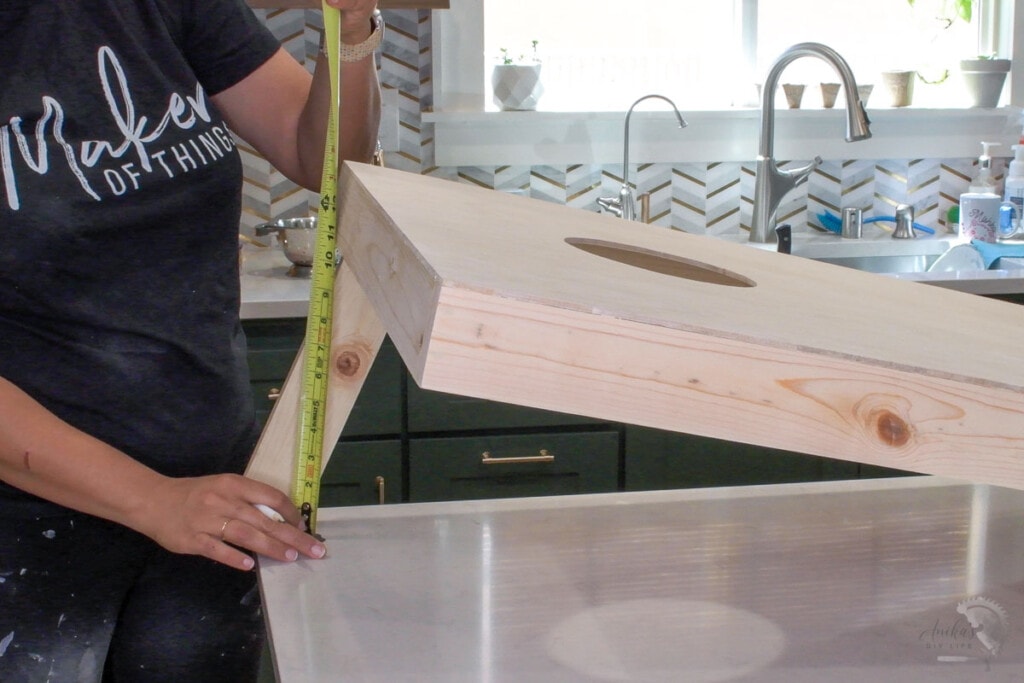 Woman measuring how to cut the legs of the cornholeboards