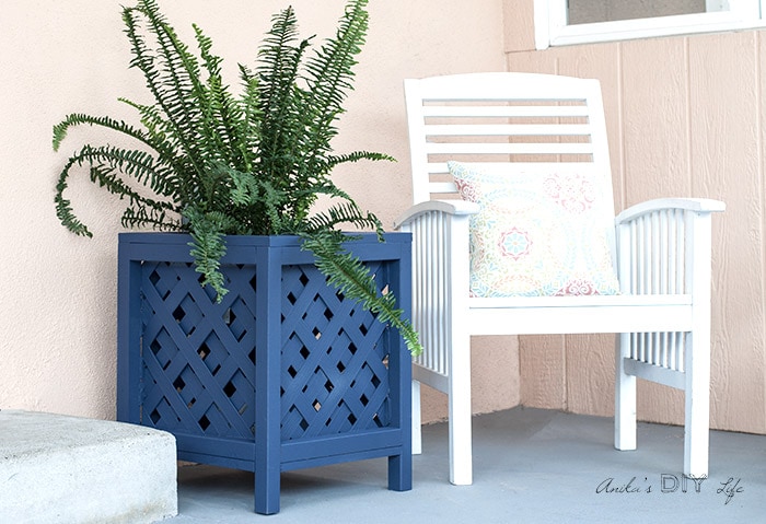 Navy blue lattice planter box in patio with plants