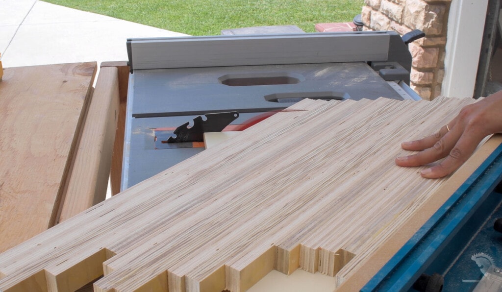 Using a crosscut sled on table saw to cut the patterned plywood panel